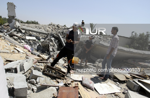 Palestinians inspect a destroyed of their house in the Bureij refugee camp in the central Gaza Strip on 01 August 2014. 