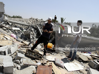 Palestinians inspect a destroyed of their house in the Bureij refugee camp in the central Gaza Strip on 01 August 2014. (