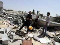 Palestinians inspect a destroyed of their house in the Bureij refugee camp in the central Gaza Strip on 01 August 2014. (