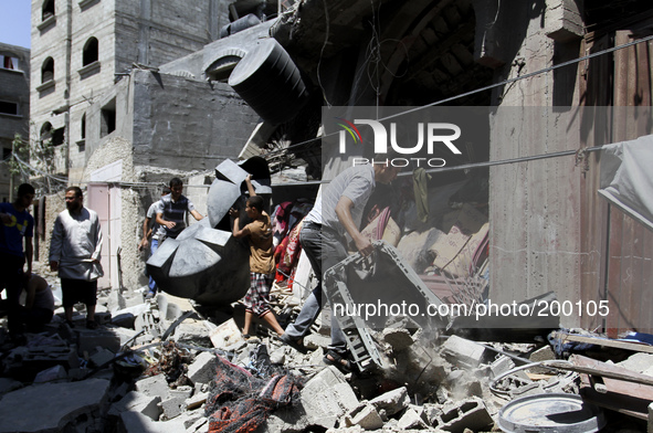 Palestinians inspect a destroyed house in the Bureij refugee camp in the central Gaza Strip on 01 August 2014. 