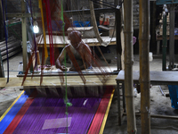 A Bangladeshi weaver weaves Benarasi sari (Woman Wear) on a traditional wooden hand weaving loom at Mirpur in Dhaka, Bangladesh. On June 05,...