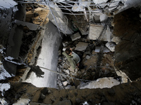 A Palestinian man search for bodies at the rubble of the destroyed house for the Al-Bayoumi family in the al-Nusairat refugee camp in the ce...