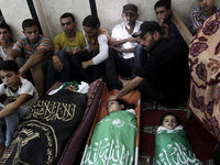 Relatives gather around the bodies of Palestinian from Alasar family, and al-Bayoumi family during their funeral in the mosque in the al-Nus...
