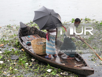  A boatman ride his boat with passenger in the polluted water near the riverbank of Buriganga on the eve of World Environment Day in Dhaka,...