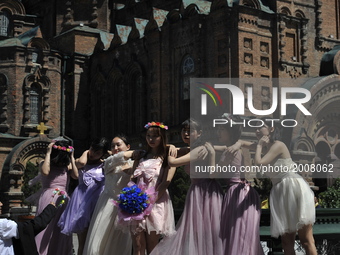 Chinese college graduates wearing wedding dress at St. Sophia Cathedral in Harbin as they take their group graduation photograph at Harbin o...