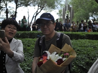 A father put flowers waiting in front of the school where their students are attending the China's annual national college entrance examinat...