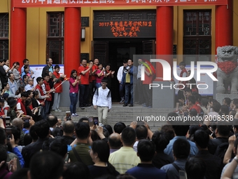 Students with parents and teachers pose for photos in front of the school where their students are attending the China's annual national col...
