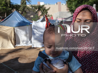 A mother holding her baby at the refugee camp set up behind the Al-Shifaa Hospital. Lack of nutrients and access to clean water might worsen...