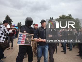 Russian police officers detain a participant of an unauthorized opposition rally in the centre of Saint Petersburg on June 12, 2017.  About...