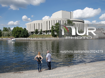 A couple is seen on the bank of the river Brda with the opera building in the background on 15 June, 2017. (