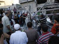Palestinians search through the rubble for survivors following an Israeli air strike, that killed nine members of al-Ghul family, on August...