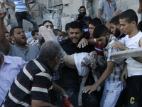 Palestinians carry the body of a boy from the al-Ghul family, who died along with eight other family members after their house was hit by an...