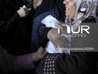 Relatives carry the body of a baby during the funeral of at least 9 members of the same al-Ghul family who died after their house was hit by...