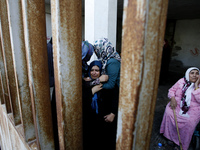 Relatives mourn during the funeral of at least 9 members of the same al-Ghul family who died after their house was hit by an Israeli air str...