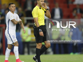 Referee Damir Skomina (R) listens to Video Assistant Referee (VAR) prior to taking decision on allowing a goal scored by Eduardo Vargas (L)...