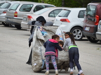 A Syrian refugee mother and her children carry a garbage bag on the road on World Refugee Day in Ankara, Turkey on June 20, 2017. The day is...