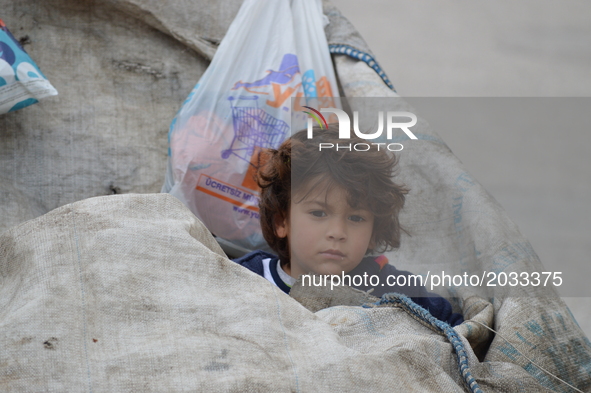 A Syrian refugee boy sits on a garbage bag on World Refugee Day in Ankara, Turkey on June 20, 2017. The day is internationally observed on J...