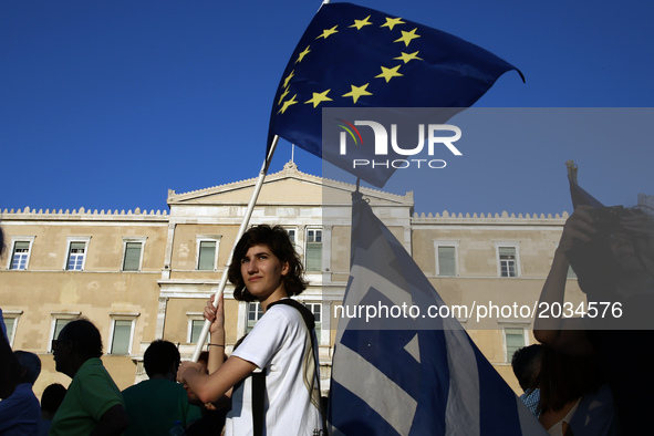 A woman holds a EU flag taking part to a rally organized by the Paraitithite (Resign) movement, at Syntagma Square, central Athens calling f...