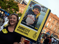 A woman holds a placard reading 'Welcome to refugees'. For the World Refugees Days, NGOs like Amnesty International, Medecins sans frontière...