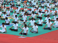Indian students perform yoga  to mark World Yoga Day at parade ground during rains, in Allahabad on June 21,2017. (