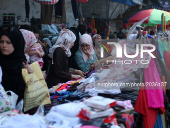 Palestinians buy Clothing, shoes and games  in a market in  Gaza Strip ahead of Eid al-Fitr holiday, which will mark the end of the holy mon...