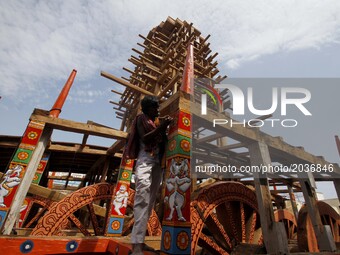 Traditional workers of the Shree Jagannath temple busy to built wooden chariots and applying colors into it it ahead of the Three deities an...