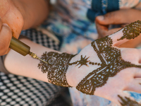 A Maroccan girl has decorative henna designs applied to her hands at a roadside stall ahead of Laylat al-Qadr celebrations in Rabat, Morocco...