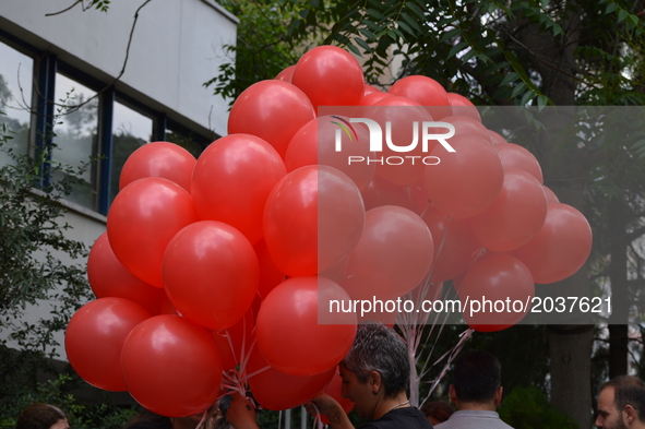 A woman holds red balloons to release them into the sky in support of sacked academic Nuriye Gulmen and primary school teacher Semih Ozakca...