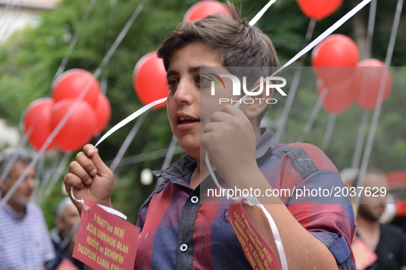 A boy holds red balloons to release them into the sky in support of sacked academic Nuriye Gulmen and primary school teacher Semih Ozakca in...