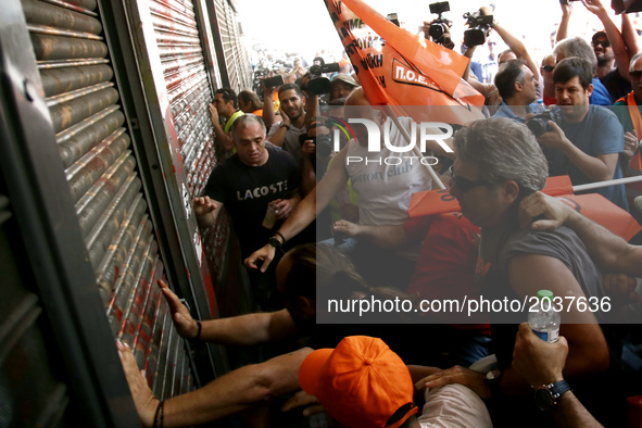 Protesters try to enter the Greek Interior ministry during a protest march organized by the Federation of workers in municipalities in Athen...