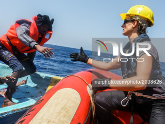 LAMPEDUSA, ITALY - MAY 19: A man is helped off a small rubber boat by crew members from NGO Sea-Eye on May 19, 2017 in international waters...