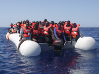 LAMPEDUSA, ITALY - MAY 19: Refugees and migrants are seen floating in an overcrowded rubber boat as they wait to be assisted by search and r...