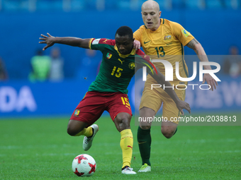 Sebastien Siani (L) of the Cameroon national football team and Aaron Mooy of the Australia national football team vie for the ball during th...