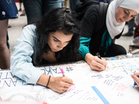 People write messages for Nabra Hassanen, Philando Castile, and Charleena Chavon during a candlelight vigil for victims of hate crimes and s...