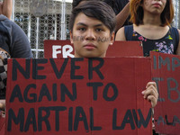 A student activist holds a slogan during a rally against Martial Law in Mindanao at the University of the Philippines in Quezon City on Frid...