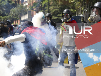 Opposition activists wearing gas masks clash with riot police during an anti-government protest in Caracas, on June 22, 2017.  (