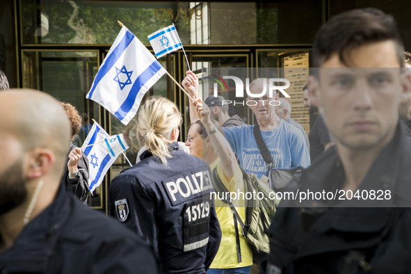 People carrying a flag of Israel protest escorted from the police as an Al-Quds-Day demonstration passes by in Berlin, Germany on June 23, 2...