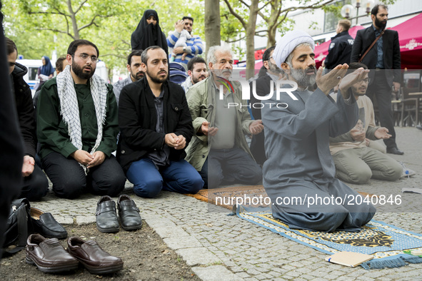 Imam Hamid Reza Torabi and other men pray before the beginning of an Al-Quds-Day demonstration in Berlin, Germany on June 23, 2017. 
