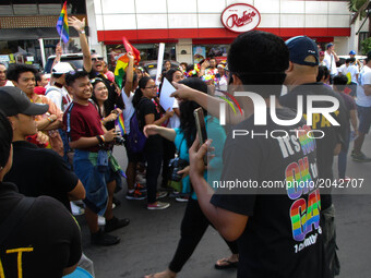 An anti-LGBT (lesbian, gay, bisexual, and transgender) activist leers at passing LGBT members and supporters during the annual LGBT Pride Pa...