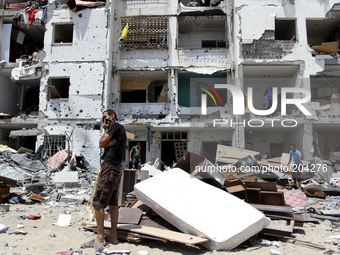 Palestinians inspect in the rubble of their destroyed apartment in a building hit by an Israeli strike in Beit Lahiya, northern Gaza Strip o...