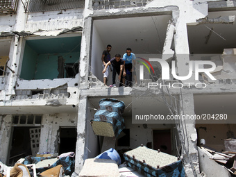 Palestinians salvage some of belongings from the rubble of their destroyed apartment in a building hit by an Israeli strike in Beit Lahiya,...