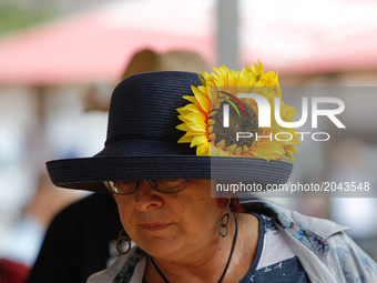 A womand is seen wearing a hat with a sunflower attached during a food festival in Bydgoszcz, Poland Locally made cheeses are seen for sale...