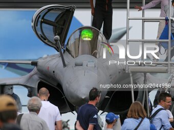 Visitors walk on the tarmac in front of  a French Dassault Aviation Rafale jetfighter on the last day of the International Paris Air Show at...