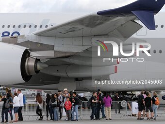 Visitors walk on the tarmac in front of  a Airbus A380 on the last day of the International Paris Air Show at Le Bourget Airport, near Paris...