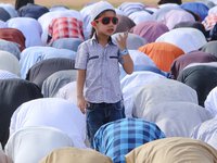 A Sri Lankan Muslim boy stands out while adult men attends the Eid al-Fitr prayers to mark the end of the holy fasting month of Ramadan in C...