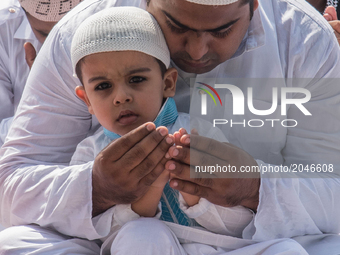 A Father teaching his kid the gestures of offering his prayers to Allah during the Namaz prayers of Eid al-fitr.Kolkata,India.26.6.2017. (