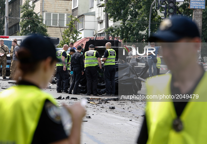 Forensic police experts and military intelligence examine the wreckage of a car in Kyiv, Ukraine, June 27, 2017. The commander of Ukraine's...