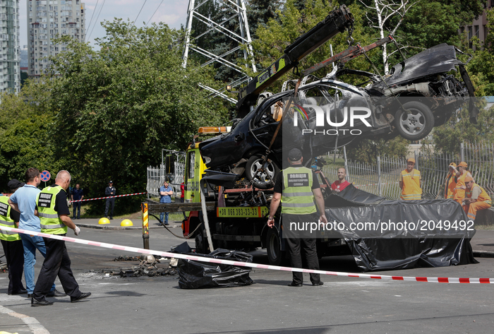 Police remove the wreckage of an exploded car after the examination in Kyiv, Ukraine, June 27, 2017. The commander of Ukraine's military int...
