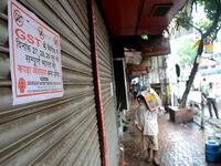 An Indian man walks past closed shops  at Burrabazar during the daylong nationwide strike, demanding changes in the GST regime in Kolkata ,...