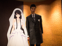 TOKYO, JAPAN - JUNE 30: Anime fan posses with his new VR (Virtual Reality) wife after a wedding ceremony in Tokyo, Japan on June 30, 2017. A...